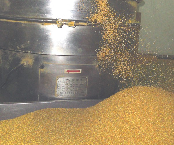 Bee pollen granules being processed in industrial equipment